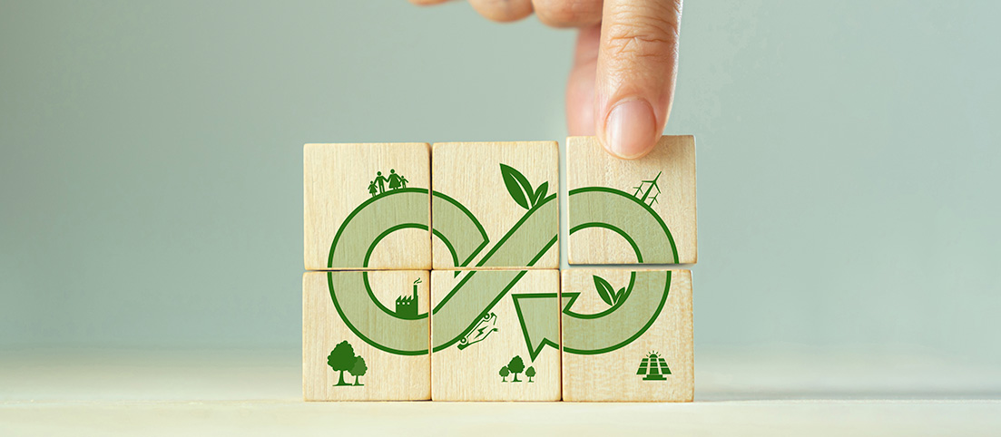 Drevené kocky s ikonami prírody, rodiny, priemyslu a symbolom nekonečna znázorňujúce cirkulárnu ekonomiku.