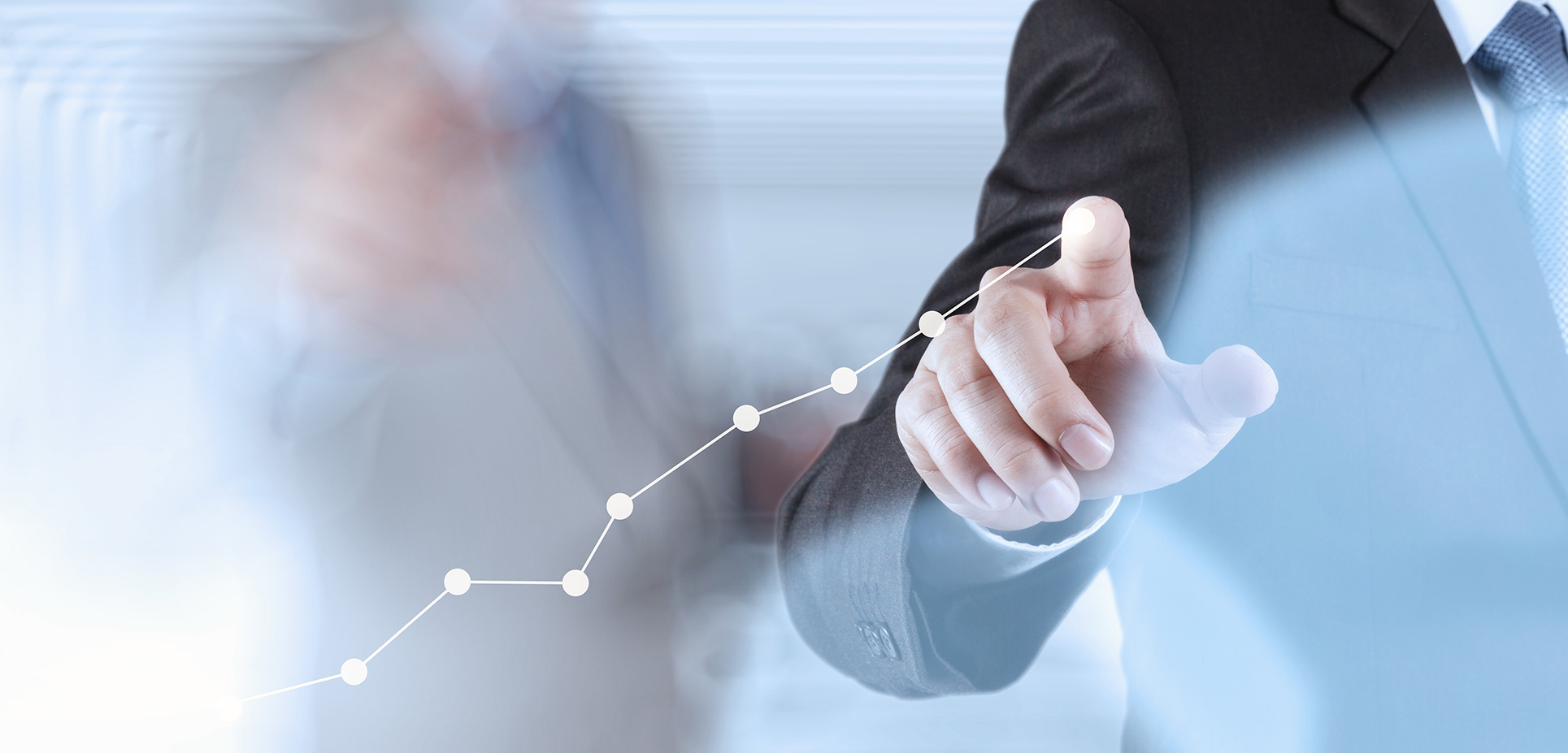 Ruka v obleku ukazuje na rastúci graf s bodmi symbolizujúci obchodný alebo finančný rast.