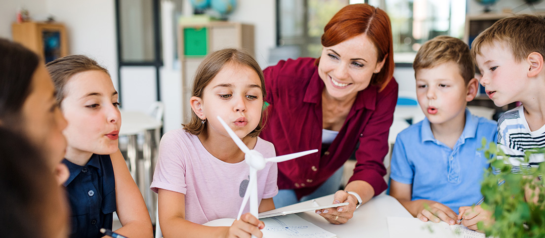 Deti fukajuce do makety vrtule veternej elektrarne