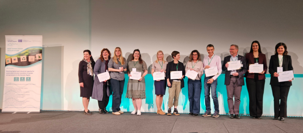 Účastníci záverečného podujatia WE.Circular stoja na pódiu a držia ocenenia získané počas slávnostného ceremoniálu Awarding Ceremony.