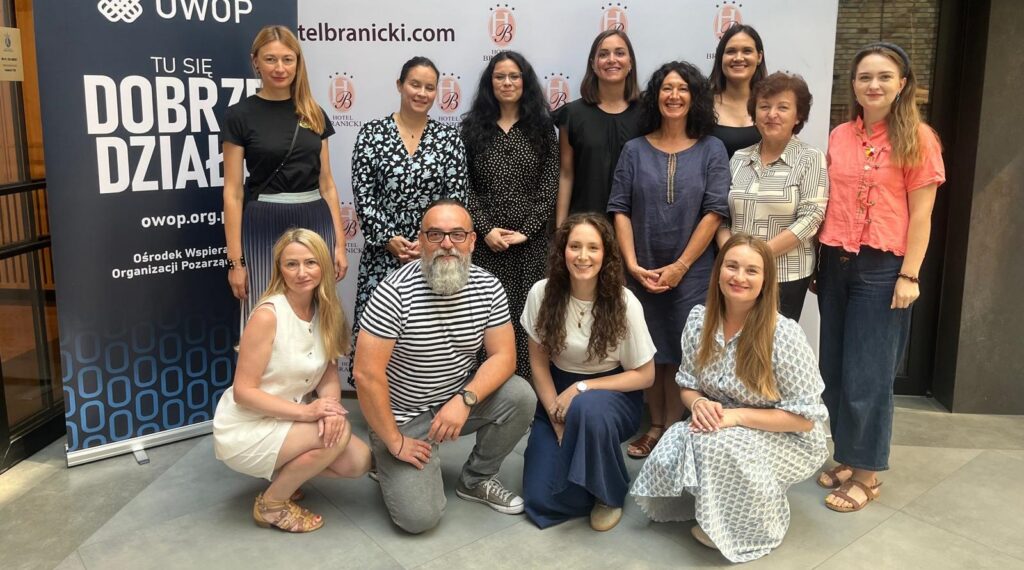 Skupinová fotografia účastníkov a školiteľa medzinárodného tréningu mentorov v Białystoku.